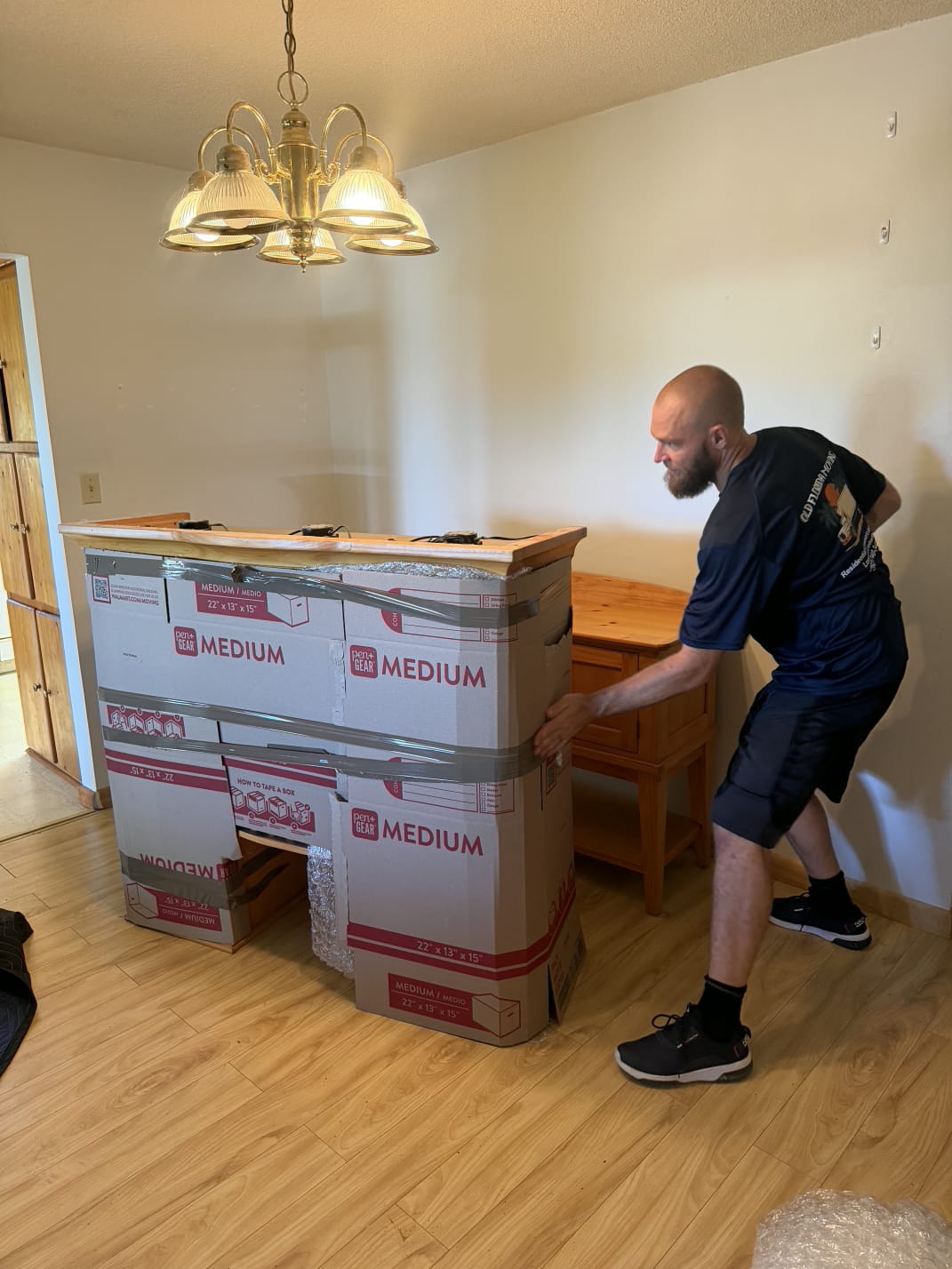 Mover adding cardboard crating over a china cabinet in Chiefland FL